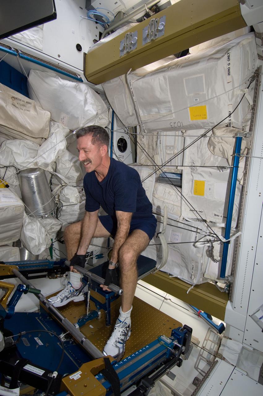 ISS030-E-012725 (18 Dec. 2011) --- NASA astronaut Dan Burbank, Expedition 30 commander, uses the short bar for the advanced Resistive Exercise Device (aRED) equipment to perform upper body strengthening pull-ups in the Tranquility node of the International Space Station.