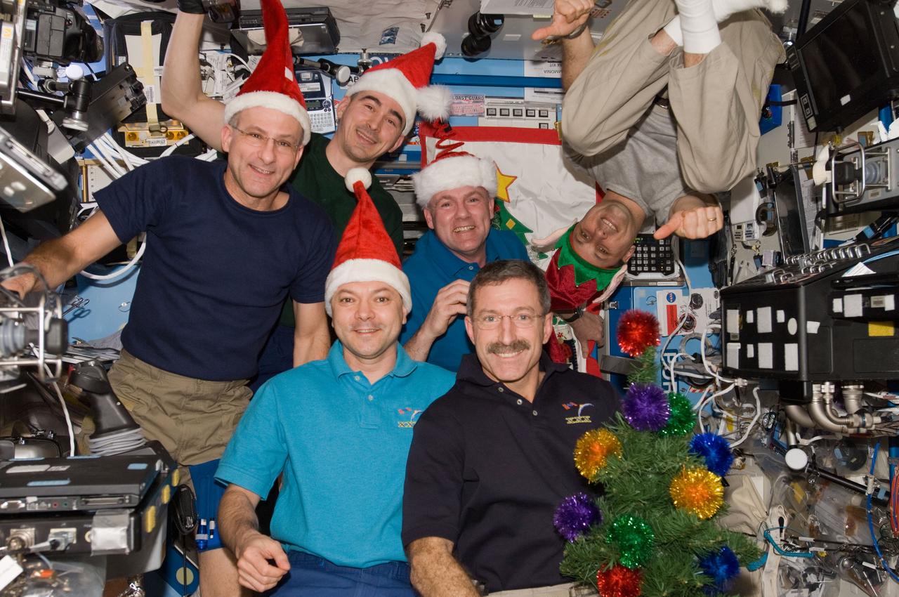 ISS030-E-015674 (25 Dec. 2011 --- The six Expedition 30 crew members assemble in the U.S. Lab (Destiny)aboard the International Space Station for a brief celebration of the Christmas holiday on Dec. 25. In front are Expedition 30 Commander Dan Burbank (right) and Flight Engineer Oleg Kononenko. On the back row, left to right, are Flight Engineers Don Pettit, Anatoly Ivanishin, Andre Kuipers and Anton Shkaplerov (suspended with his feet anchored above the group). Burbank and Pettit are NASA astronauts; Kononenko, Shkaplerov and Ivanishin are Russian cosmonauts; and Kuipers represents the European Space Agency.