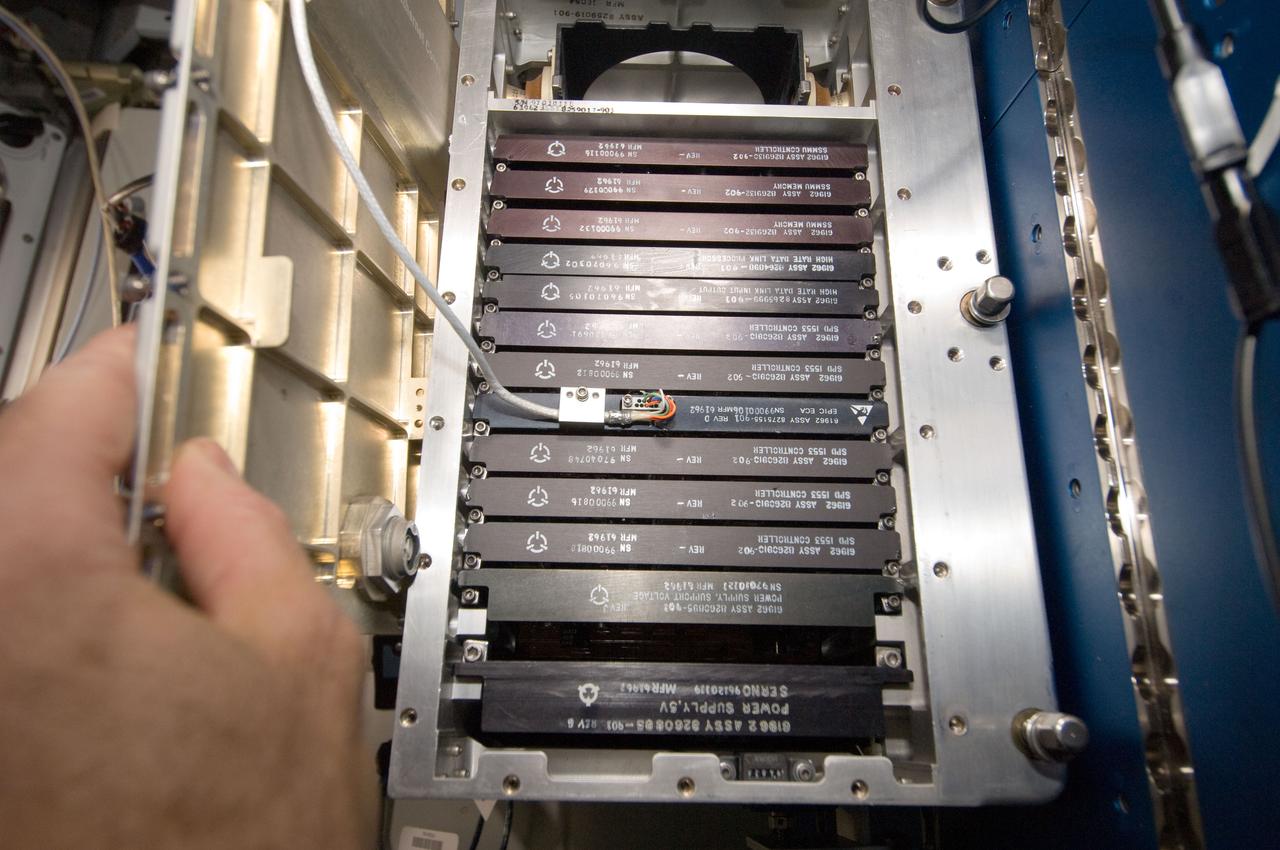 ISS030-E-017776 (29 Dec. 2011) --- Working in chorus with the International Space Station team in Houston?s Mission Control Center, this astronaut and his Expedition 30 crewmates on the station install a set of Enhanced Processor and Integrated Communications (EPIC) computer cards in one of seven primary computers onboard. The upgrade will allow more experiments to operate simultaneously, and prepare for the arrival of commercial cargo ships later this year.