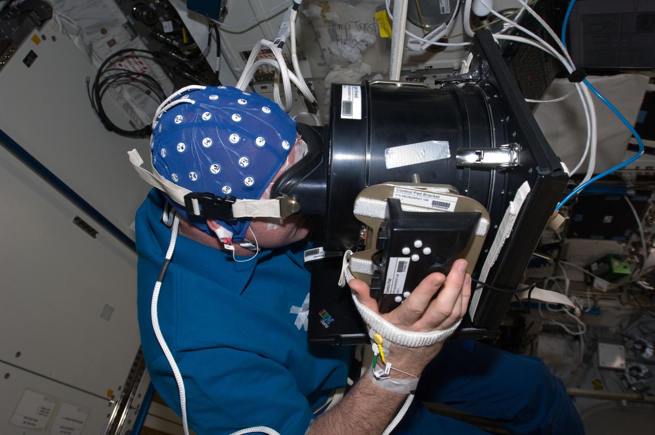 iss030e022627 (Jan. 3, 2012) --- European Space Agency (ESA) astronaut Andre Kuipers during his first orbital Neurospat session. Kuipers is wearing an Electroencephalogram (EEG) electrode cap before starting measurements. Neurospat investigates ways in which crew member's three-dimensional visual and space perception is affected by long-duration stays in weightlessness to help in help in finding and developing countermeasures alleviating any disorientation experienced by astronauts.