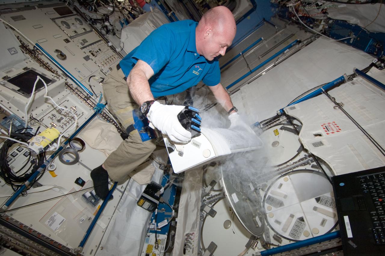 ISS030-E-033272 (24 Dec. 2011) --- European Space Agency astronaut Andre Kuipers, Expedition 30 flight engineer, prepares to insert ESA Role of Apoptosis in Lymphocyte Depression 2 (ROALD-2) experiment samples into a Minus Eighty Laboratory Freezer for ISS (MELFI-1) dewar tray located in the International Space Station's Kibo laboratory.