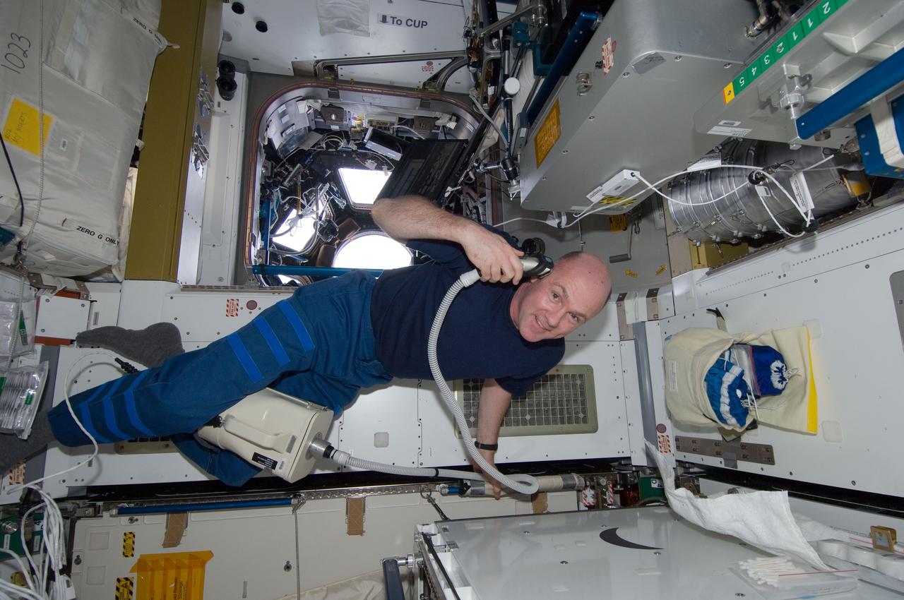 ISS030-E-033523 (30 Dec. 2011) --- European Space Agency astronaut Andre Kuipers, Expedition 30 flight engineer, trims his hair in the Tranquility node of the International Space Station. Kuipers used hair clippers fashioned with a vacuum device to garner freshly cut hair.