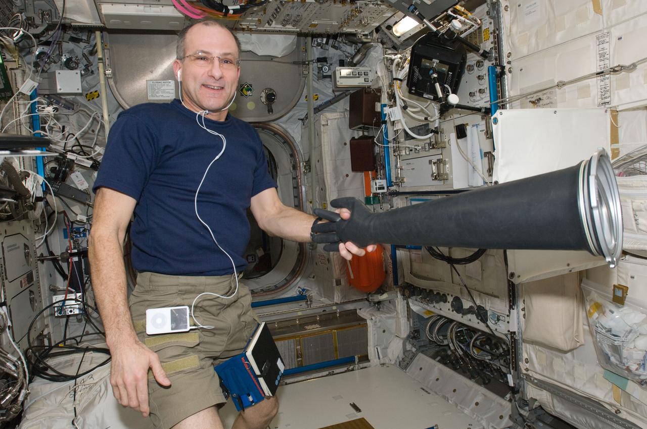 ISS030-E-049556 (17 Jan. 2012) --- NASA astronaut Don Pettit, Expedition 30 flight engineer, holds a Microgravity Science Glovebox (MSG) glove in the Columbus laboratory of the International Space Station.