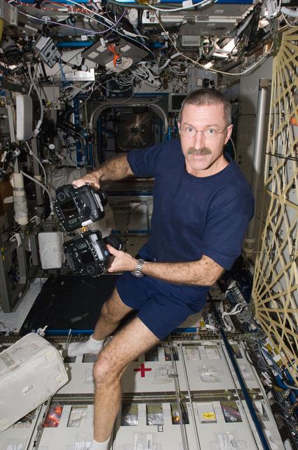 NASA image: Burbank works with two still cameras mounted together in the U.S. Laboratory