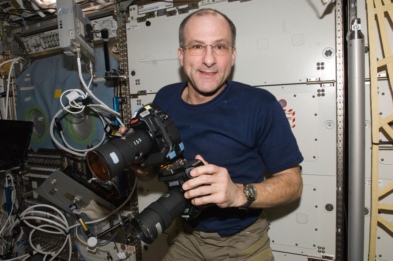 ISS030-E-049636 (21 Jan. 2012) --- NASA astronaut Don Pettit, Expedition 30 flight engineer, works with two still cameras mounted together in the Destiny laboratory of the International Space Station. One camera is an infrared modified still camera.