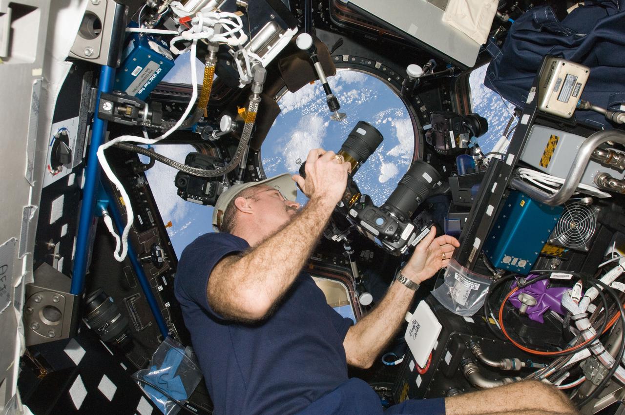 ISS030-E-049664 (21 Jan. 2012) --- NASA astronaut Dan Burbank, Expedition 30 commander, uses still cameras to photograph the topography of a point on Earth from a window in the Cupola of the International Space Station. One camera is an infrared modified still camera.