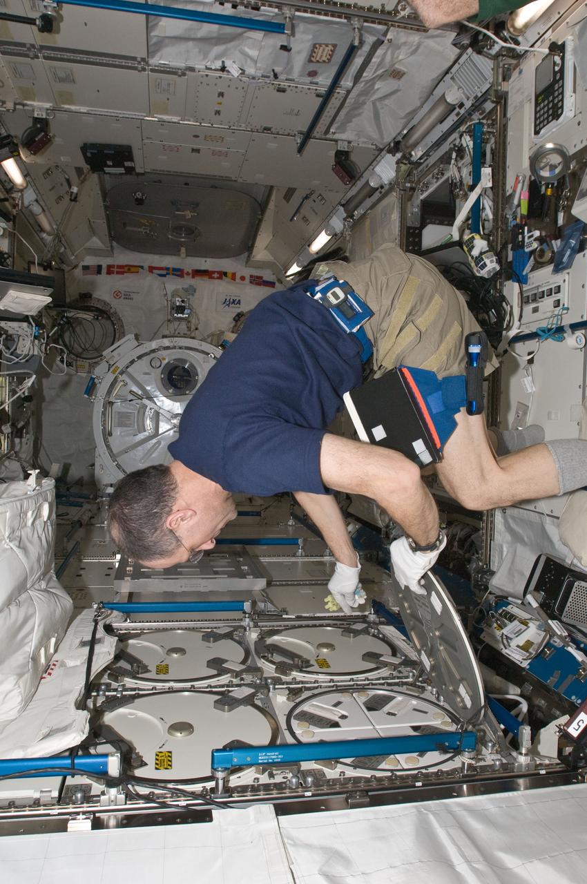 ISS030-E-050849 (26 Jan. 2012) --- NASA astronaut Don Pettit, Expedition 30 flight engineer, prepares to insert biological samples in the Minus Eighty Laboratory Freezer for ISS (MELFI-1) in the Kibo laboratory of the International Space Station.