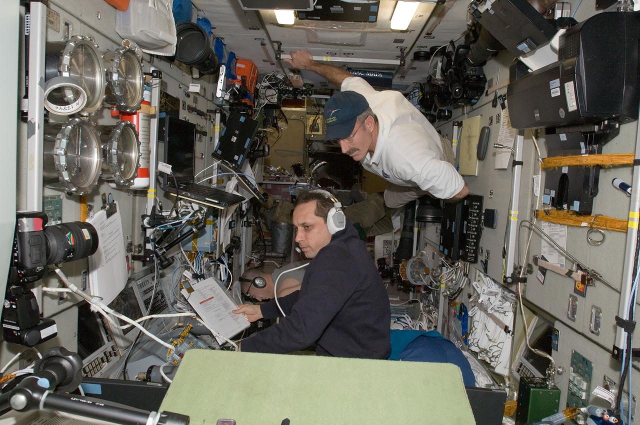 ISS030-E-050884 (27 Jan. 2012) --- Russian cosmonaut Anton Shkaplerov (bottom), Expedition 30 flight engineer, monitors data at the manual TORU docking system controls in the Zvezda Service Module of the International Space Station during approach and docking operations of the unpiloted ISS Progress 46 resupply vehicle. Progress 46 docked automatically to the Pirs Docking Compartment via the Kurs automated rendezvous system at 7:00 p.m. (EST) on Jan. 27, 2012. NASA astronaut Dan Burbank, commander, looks on. Russian cosmonaut Anatoly Ivanishin (bottom background), flight engineer, photographs the approach of the Progress from a Zvezda window.