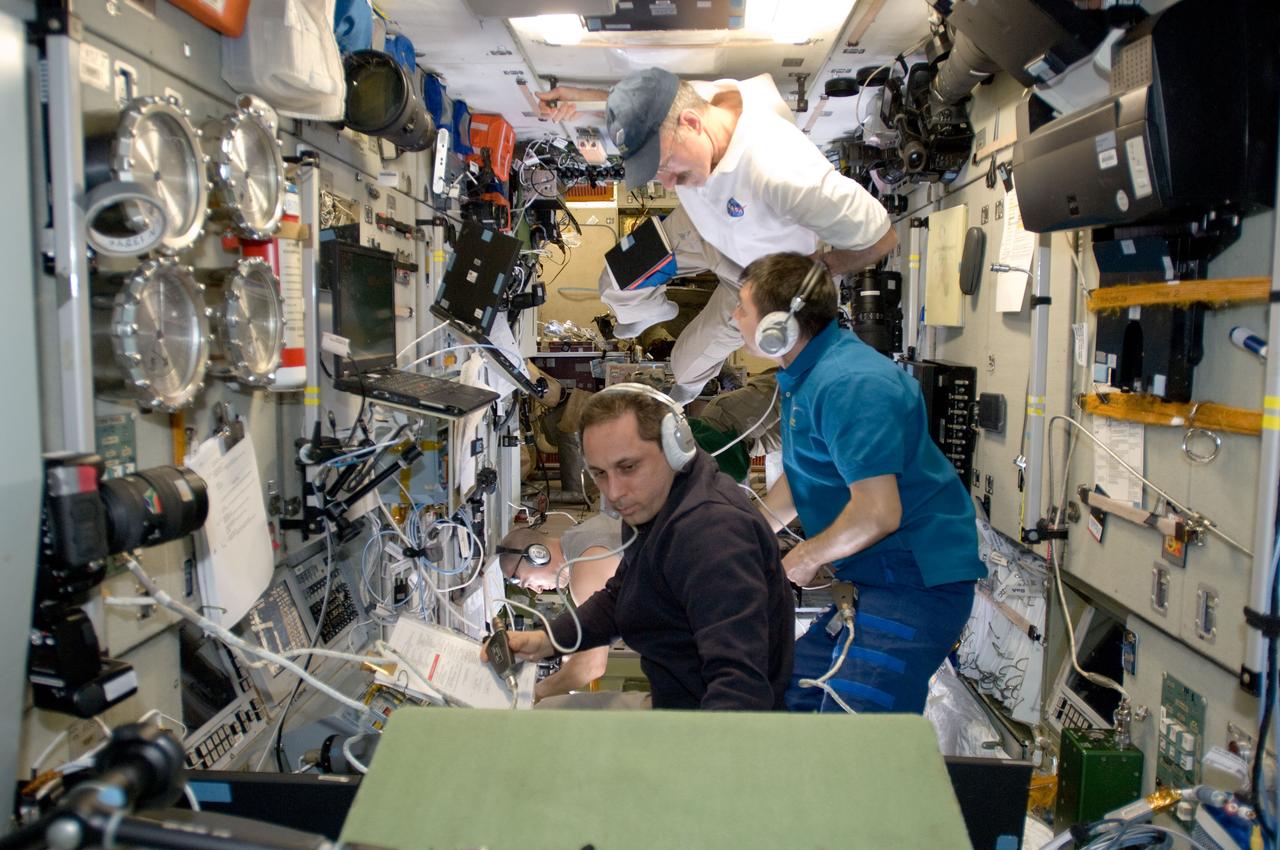ISS030-E-050885 (27 Jan. 2012) --- Russian cosmonauts Anton Shkaplerov (bottom) and Oleg Kononenko (center), both Expedition 30 flight engineers, monitor data at the manual TORU docking system controls in the Zvezda Service Module of the International Space Station during approach and docking operations of the unpiloted ISS Progress 46 resupply vehicle. Progress 46 docked automatically to the Pirs Docking Compartment via the Kurs automated rendezvous system at 7:00 p.m. (EST) on Jan. 27, 2012. NASA astronaut Dan Burbank, commander, looks on. Russian cosmonaut Anatoly Ivanishin (bottom background), flight engineer, photographs the approach of the Progress from a Zvezda window.