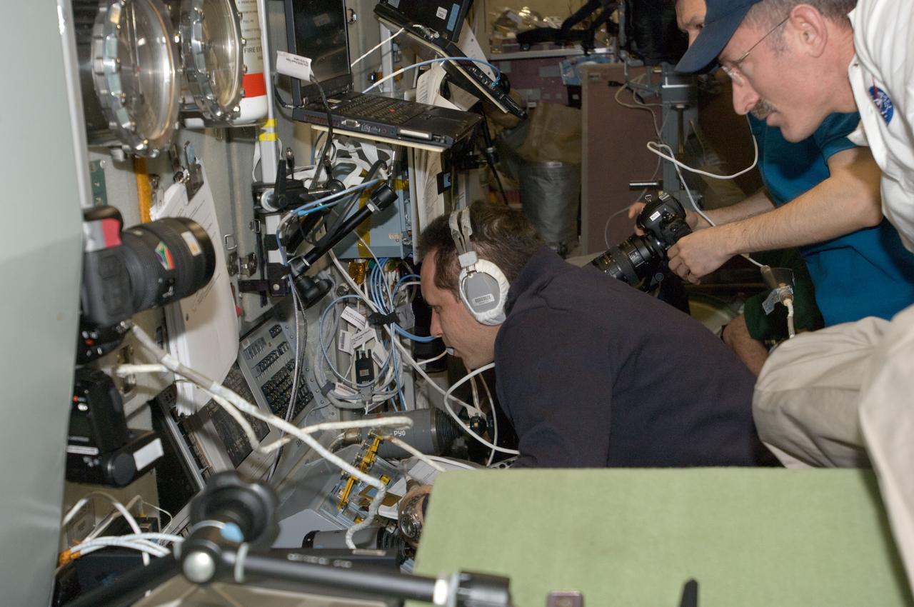 ISS030-E-050933 (27 Jan. 2012) --- Russian cosmonauts Anton Shkaplerov (left) and Oleg Kononenko (partially obscured), both Expedition 30 flight engineers, monitor data at the manual TORU docking system controls in the Zvezda Service Module of the International Space Station during approach and docking operations of the unpiloted ISS Progress 46 resupply vehicle. Progress 46 docked automatically to the Pirs Docking Compartment via the Kurs automated rendezvous system at 7:00 p.m. (EST) on Jan. 27, 2012. NASA astronaut Dan Burbank (partially out of frame at right), commander, looks on.