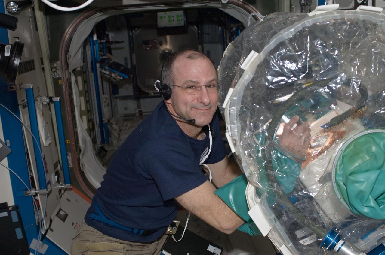 ISS030-E-051104 (27 Jan. 2012) --- NASA astronaut Don Pettit, Expedition 30 flight engineer, works on a Synchronized Position Hold, Engage, Reorient, Experimental Satellite (SPHERES) in a portable glovebox facility in the Destiny laboratory of the International Space Station.