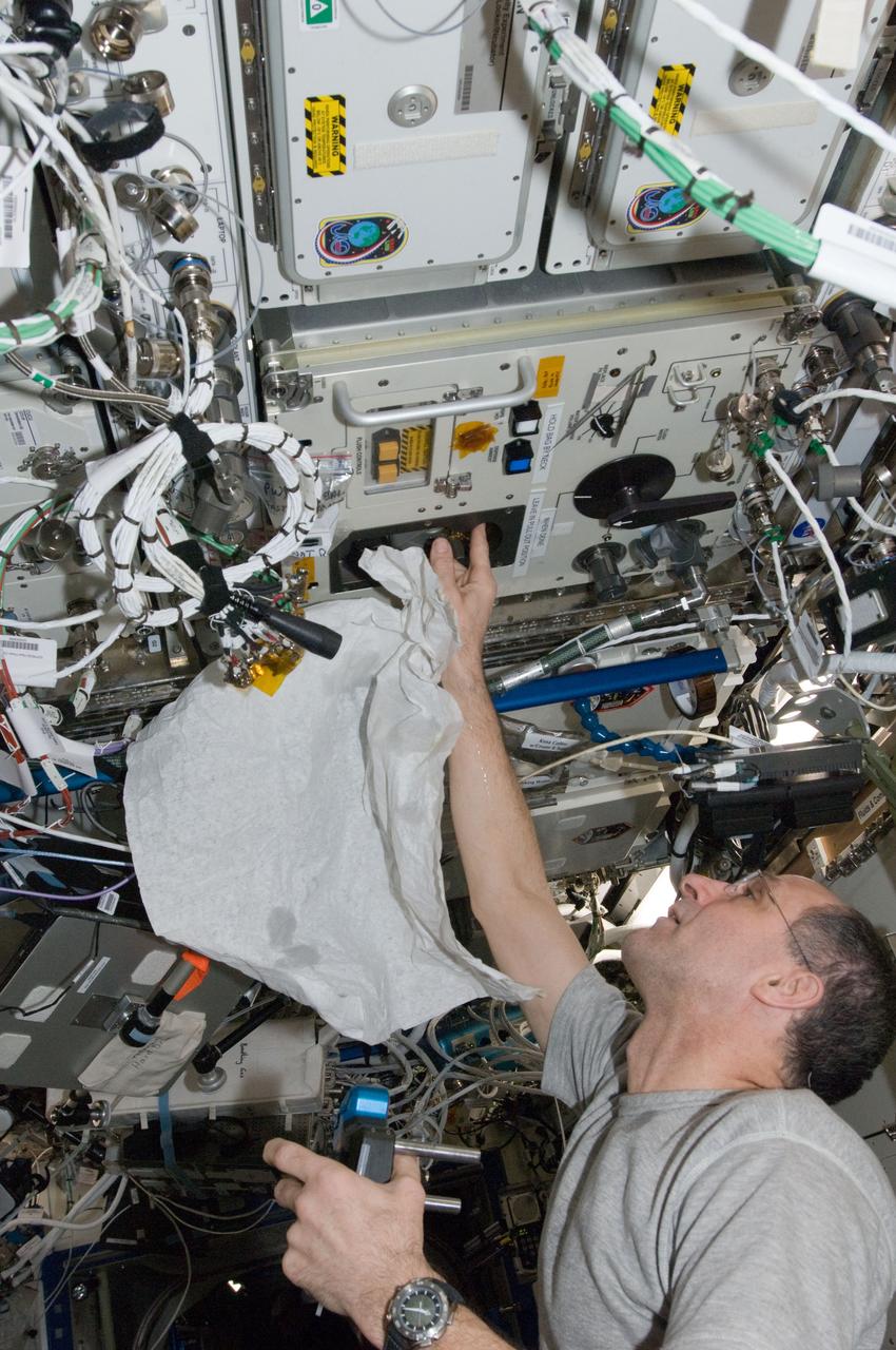 ISS030-E-074046 (12 Feb. 2012) --- NASA astronaut Don Pettit, Expedition 30 flight engineer, performs in-flight maintenance on the Potable Water Dispenser (PWD) in the Destiny laboratory of the International Space Station.