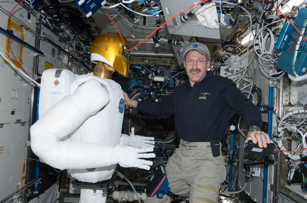ISS030-E-074075 (15 Feb. 2012) --- Robonaut 2, nicknamed R2, and NASA astronaut Dan Burbank, Expedition 30 commander, are pictured in the Destiny laboratory of the International Space Station during R2?s initial checkouts.