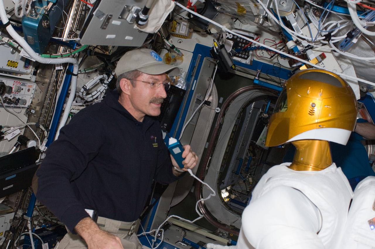 ISS030-E-075362 (14 Feb. 2012) --- NASA astronaut Dan Burbank, Expedition 30 commander, uses a communication system while working with Robonaut 2 in the Destiny laboratory of the International Space Station.