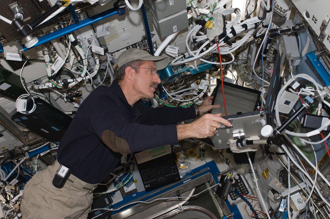 ISS030-E-075364 (14 Feb. 2012) --- NASA astronaut Dan Burbank, Expedition 30 commander, uses a computer while working with Robonaut 2 (out of frame) in the Destiny laboratory of the International Space Station.