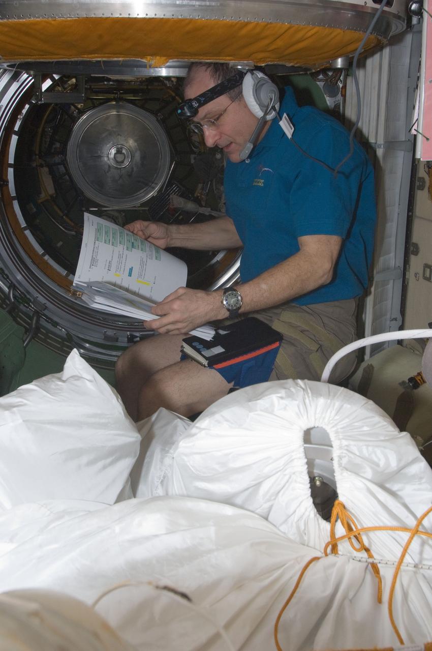 ISS030-E-078304 (16 Feb. 2012) --- NASA astronaut Don Pettit, Expedition 30 flight engineer, reads a procedures checklist in the Zarya Functional Cargo Block (FGB) of the International Space Station as the crew prepares for a session of extravehicular activity (EVA) to continue outfitting the International Space Station.