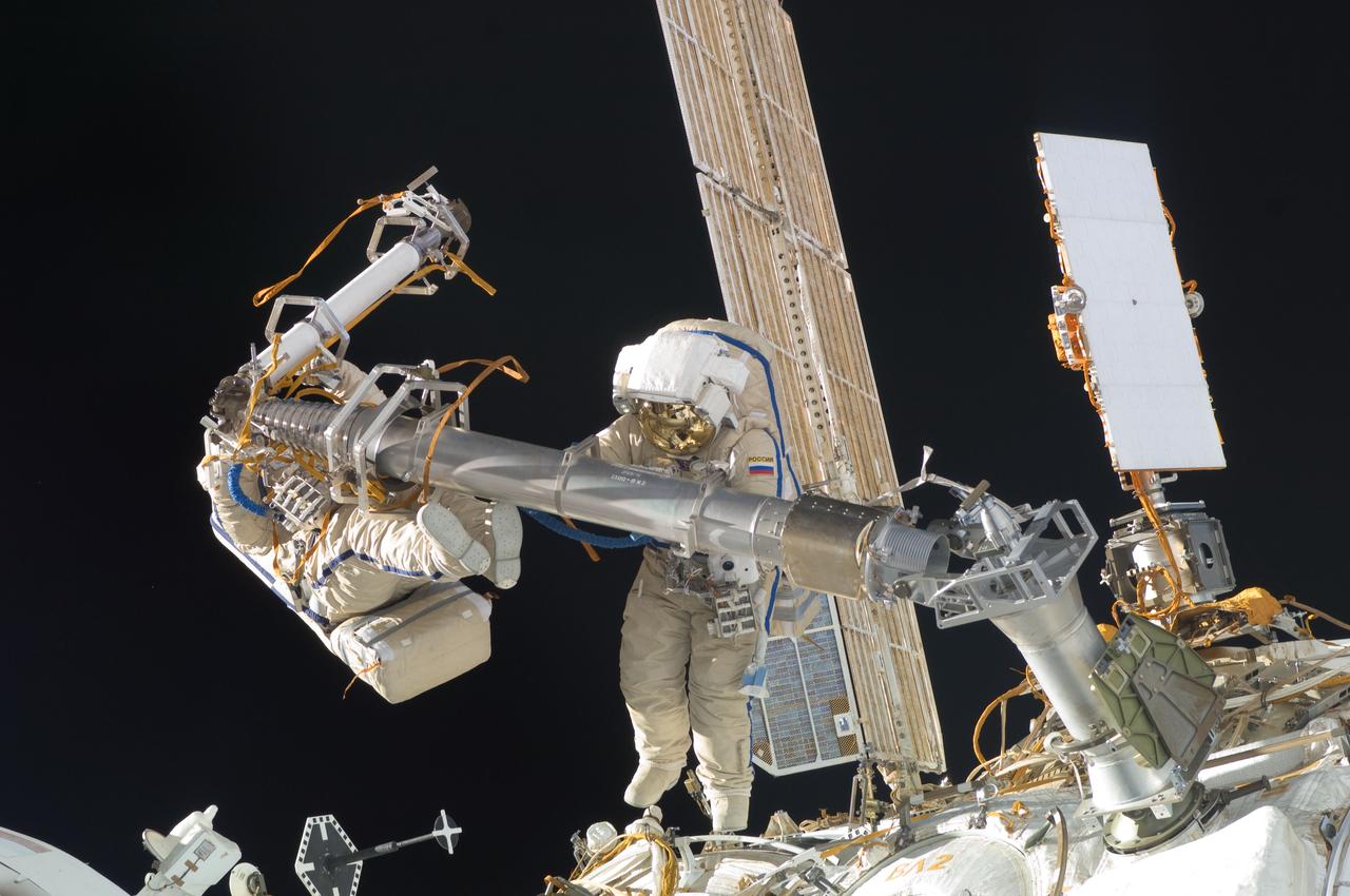 ISS030-E-078377 (16 Feb. 2012) --- Russian cosmonauts Oleg Kononenko and Anton Shkaplerov, both Expedition 30 flight engineers, participate in a session of extravehicular activity (EVA) to continue outfitting the International Space Station. During the six-hour, 15-minute spacewalk, Kononenko and Shkaplerov moved the Strela-1 crane from the Pirs Docking Compartment to begin preparing the Pirs for its replacement next year with a new laboratory and docking module. The duo used another boom, the Strela-2, to move the hand-operated crane to the Poisk module for future assembly and maintenance work. Both telescoping booms extend like fishing rods and are used to move massive components outside the station. On the exterior of the Poisk Mini-Research Module 2 (MRM2), they also installed the Vinoslivost Materials Sample Experiment, which will investigate the influence of space on the mechanical properties of the materials. The spacewalkers also collected a test sample from underneath the insulation on the Zvezda Service Module to search for any signs of living organisms. Both spacewalkers wore Russian Orlan spacesuits bearing blue stripes and equipped with NASA helmet cameras.