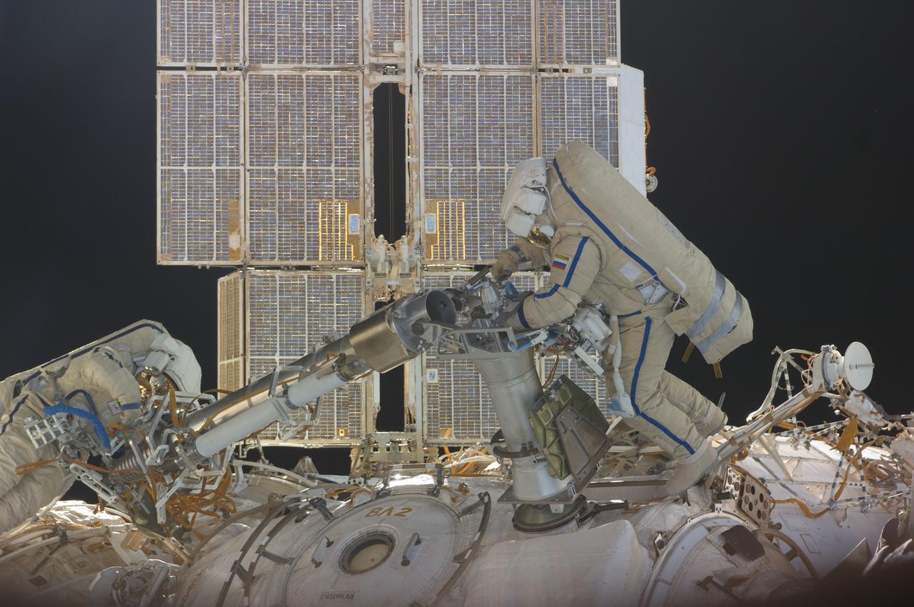 ISS030-E-078391 (16 Feb. 2012) --- Russian cosmonauts Oleg Kononenko and Anton Shkaplerov, both Expedition 30 flight engineers, participate in a session of extravehicular activity (EVA) to continue outfitting the International Space Station. During the six-hour, 15-minute spacewalk, Kononenko and Shkaplerov moved the Strela-1 crane from the Pirs Docking Compartment to begin preparing the Pirs for its replacement next year with a new laboratory and docking module. The duo used another boom, the Strela-2, to move the hand-operated crane to the Poisk module for future assembly and maintenance work. Both telescoping booms extend like fishing rods and are used to move massive components outside the station. On the exterior of the Poisk Mini-Research Module 2 (MRM2), they also installed the Vinoslivost Materials Sample Experiment, which will investigate the influence of space on the mechanical properties of the materials. The spacewalkers also collected a test sample from underneath the insulation on the Zvezda Service Module to search for any signs of living organisms. Both spacewalkers wore Russian Orlan spacesuits bearing blue stripes and equipped with NASA helmet cameras.