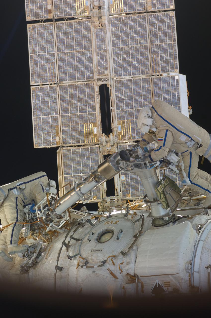 ISS030-E-078393 (16 Feb. 2012) --- Russian cosmonauts Oleg Kononenko and Anton Shkaplerov, both Expedition 30 flight engineers, participate in a session of extravehicular activity (EVA) to continue outfitting the International Space Station. During the six-hour, 15-minute spacewalk, Kononenko and Shkaplerov moved the Strela-1 crane from the Pirs Docking Compartment to begin preparing the Pirs for its replacement next year with a new laboratory and docking module. The duo used another boom, the Strela-2, to move the hand-operated crane to the Poisk module for future assembly and maintenance work. Both telescoping booms extend like fishing rods and are used to move massive components outside the station. On the exterior of the Poisk Mini-Research Module 2 (MRM2), they also installed the Vinoslivost Materials Sample Experiment, which will investigate the influence of space on the mechanical properties of the materials. The spacewalkers also collected a test sample from underneath the insulation on the Zvezda Service Module to search for any signs of living organisms. Both spacewalkers wore Russian Orlan spacesuits bearing blue stripes and equipped with NASA helmet cameras.