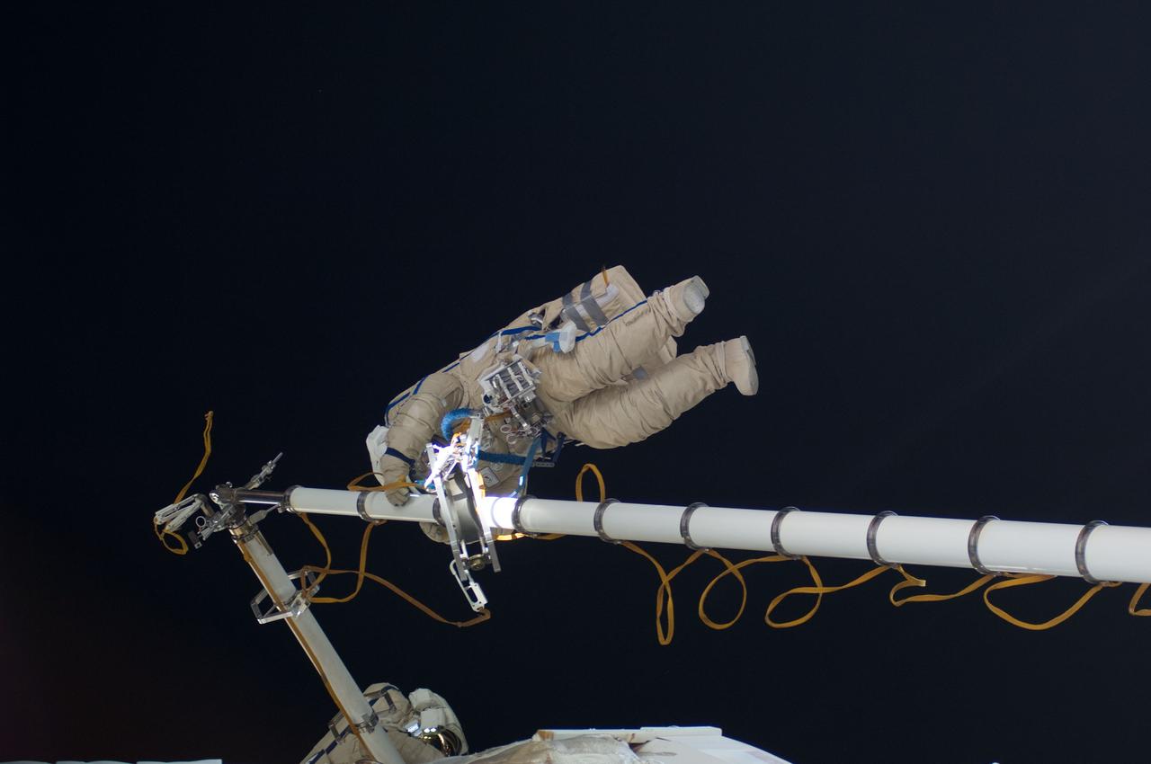 ISS030-E-078488 (16 Feb. 2012) --- Russian cosmonauts Oleg Kononenko and Anton Shkaplerov, both Expedition 30 flight engineers, participate in a session of extravehicular activity (EVA) to continue outfitting the International Space Station. During the six-hour, 15-minute spacewalk, Kononenko and Shkaplerov moved the Strela-1 crane from the Pirs Docking Compartment to begin preparing the Pirs for its replacement next year with a new laboratory and docking module. The duo used another boom, the Strela-2, to move the hand-operated crane to the Poisk module for future assembly and maintenance work. Both telescoping booms extend like fishing rods and are used to move massive components outside the station. On the exterior of the Poisk Mini-Research Module 2 (MRM2), they also installed the Vinoslivost Materials Sample Experiment, which will investigate the influence of space on the mechanical properties of the materials. The spacewalkers also collected a test sample from underneath the insulation on the Zvezda Service Module to search for any signs of living organisms. Both spacewalkers wore Russian Orlan spacesuits bearing blue stripes and equipped with NASA helmet cameras.