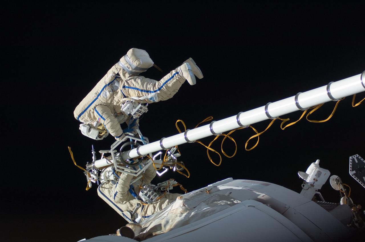 ISS030-E-078522 (16 Feb. 2012) --- Russian cosmonauts Oleg Kononenko and Anton Shkaplerov, both Expedition 30 flight engineers, participate in a session of extravehicular activity (EVA) to continue outfitting the International Space Station. During the six-hour, 15-minute spacewalk, Kononenko and Shkaplerov moved the Strela-1 crane from the Pirs Docking Compartment to begin preparing the Pirs for its replacement next year with a new laboratory and docking module. The duo used another boom, the Strela-2, to move the hand-operated crane to the Poisk module for future assembly and maintenance work. Both telescoping booms extend like fishing rods and are used to move massive components outside the station. On the exterior of the Poisk Mini-Research Module 2 (MRM2), they also installed the Vinoslivost Materials Sample Experiment, which will investigate the influence of space on the mechanical properties of the materials. The spacewalkers also collected a test sample from underneath the insulation on the Zvezda Service Module to search for any signs of living organisms. Both spacewalkers wore Russian Orlan spacesuits bearing blue stripes and equipped with NASA helmet cameras.