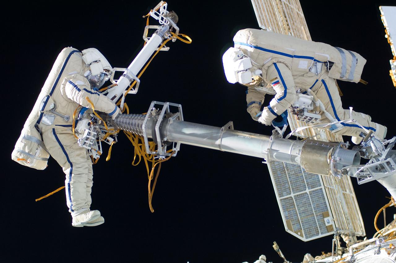 ISS030-E-078533 (16 Feb. 2012) --- Russian cosmonauts Oleg Kononenko and Anton Shkaplerov, both Expedition 30 flight engineers, participate in a session of extravehicular activity (EVA) to continue outfitting the International Space Station. During the six-hour, 15-minute spacewalk, Kononenko and Shkaplerov moved the Strela-1 crane from the Pirs Docking Compartment to begin preparing the Pirs for its replacement next year with a new laboratory and docking module. The duo used another boom, the Strela-2, to move the hand-operated crane to the Poisk module for future assembly and maintenance work. Both telescoping booms extend like fishing rods and are used to move massive components outside the station. On the exterior of the Poisk Mini-Research Module 2 (MRM2), they also installed the Vinoslivost Materials Sample Experiment, which will investigate the influence of space on the mechanical properties of the materials. The spacewalkers also collected a test sample from underneath the insulation on the Zvezda Service Module to search for any signs of living organisms. Both spacewalkers wore Russian Orlan spacesuits bearing blue stripes and equipped with NASA helmet cameras.