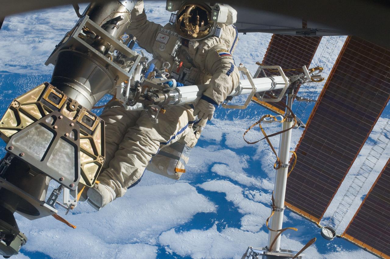 ISS030-E-079930 (16 Feb. 2012) --- Russian cosmonaut Anton Shkaplerov, Expedition 30 flight engineer, participates in a session of extravehicular activity (EVA) to continue outfitting the International Space Station. During the six-hour, 15-minute spacewalk, Shkaplerov and Russian cosmonaut Oleg Kononenko (out of frame), flight engineer, moved the Strela-1 crane from the Pirs Docking Compartment to begin preparing the Pirs for its replacement next year with a new laboratory and docking module. The duo used another boom, the Strela-2, to move the hand-operated crane to the Poisk module for future assembly and maintenance work. Both telescoping booms extend like fishing rods and are used to move massive components outside the station. On the exterior of the Poisk Mini-Research Module 2 (MRM2), they also installed the Vinoslivost Materials Sample Experiment, which will investigate the influence of space on the mechanical properties of the materials. The spacewalkers also collected a test sample from underneath the insulation on the Zvezda Service Module to search for any signs of living organisms. Both spacewalkers wore Russian Orlan spacesuits bearing blue stripes and equipped with NASA helmet cameras.