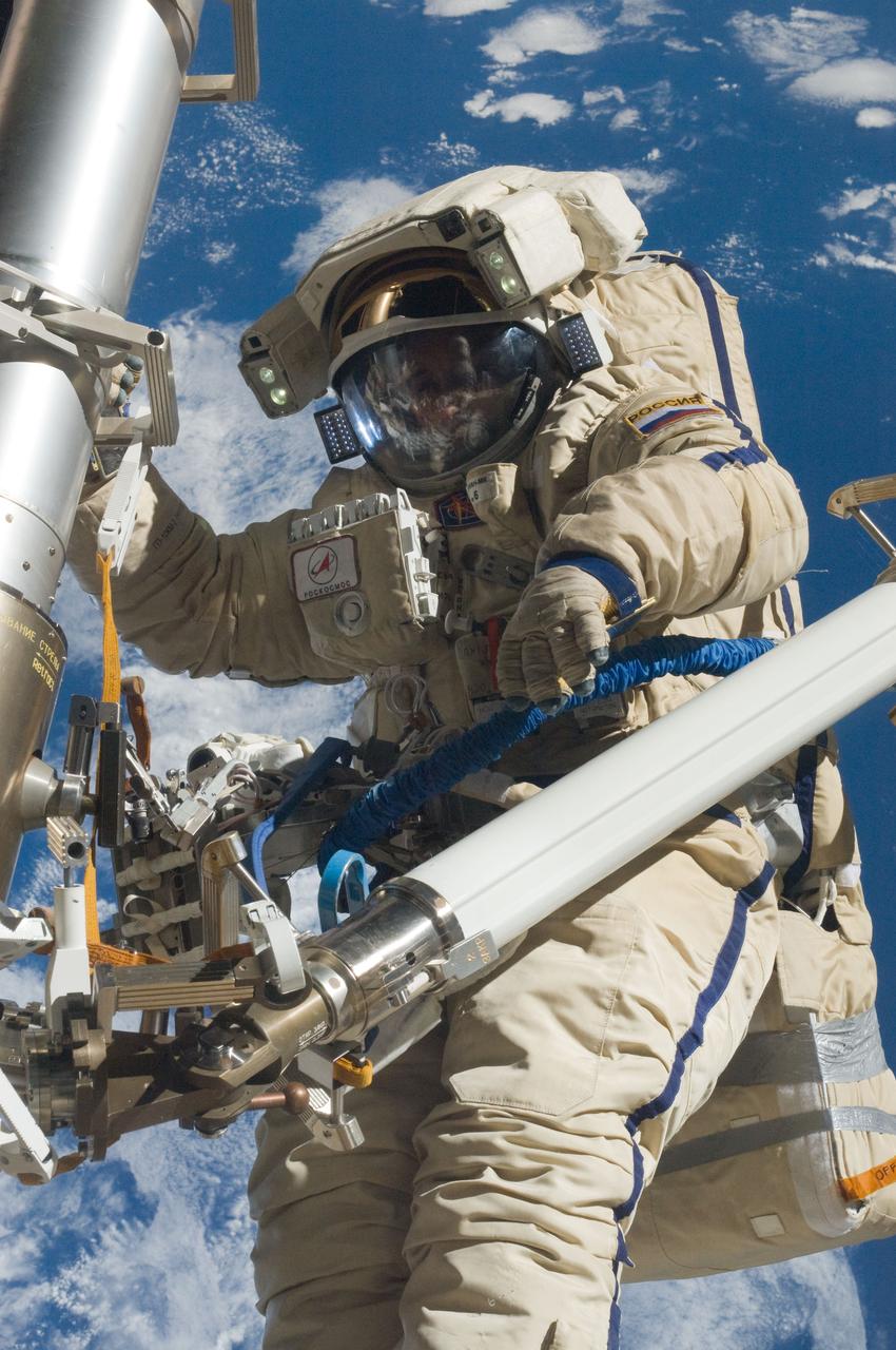 ISS030-E-079953 (16 Feb. 2012) --- Russian cosmonaut Anton Shkaplerov, Expedition 30 flight engineer, participates in a session of extravehicular activity (EVA) to continue outfitting the International Space Station. During the six-hour, 15-minute spacewalk, Shkaplerov and Russian cosmonaut Oleg Kononenko (out of frame), flight engineer, moved the Strela-1 crane from the Pirs Docking Compartment to begin preparing the Pirs for its replacement next year with a new laboratory and docking module. The duo used another boom, the Strela-2, to move the hand-operated crane to the Poisk module for future assembly and maintenance work. Both telescoping booms extend like fishing rods and are used to move massive components outside the station. On the exterior of the Poisk Mini-Research Module 2 (MRM2), they also installed the Vinoslivost Materials Sample Experiment, which will investigate the influence of space on the mechanical properties of the materials. The spacewalkers also collected a test sample from underneath the insulation on the Zvezda Service Module to search for any signs of living organisms. Both spacewalkers wore Russian Orlan spacesuits bearing blue stripes and equipped with NASA helmet cameras.