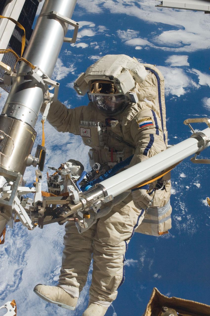 ISS030-E-079955 (16 Feb. 2012) --- Russian cosmonaut Anton Shkaplerov, Expedition 30 flight engineer, participates in a session of extravehicular activity (EVA) to continue outfitting the International Space Station. During the six-hour, 15-minute spacewalk, Shkaplerov and Russian cosmonaut Oleg Kononenko (out of frame), flight engineer, moved the Strela-1 crane from the Pirs Docking Compartment to begin preparing the Pirs for its replacement next year with a new laboratory and docking module. The duo used another boom, the Strela-2, to move the hand-operated crane to the Poisk module for future assembly and maintenance work. Both telescoping booms extend like fishing rods and are used to move massive components outside the station. On the exterior of the Poisk Mini-Research Module 2 (MRM2), they also installed the Vinoslivost Materials Sample Experiment, which will investigate the influence of space on the mechanical properties of the materials. The spacewalkers also collected a test sample from underneath the insulation on the Zvezda Service Module to search for any signs of living organisms. Both spacewalkers wore Russian Orlan spacesuits bearing blue stripes and equipped with NASA helmet cameras.