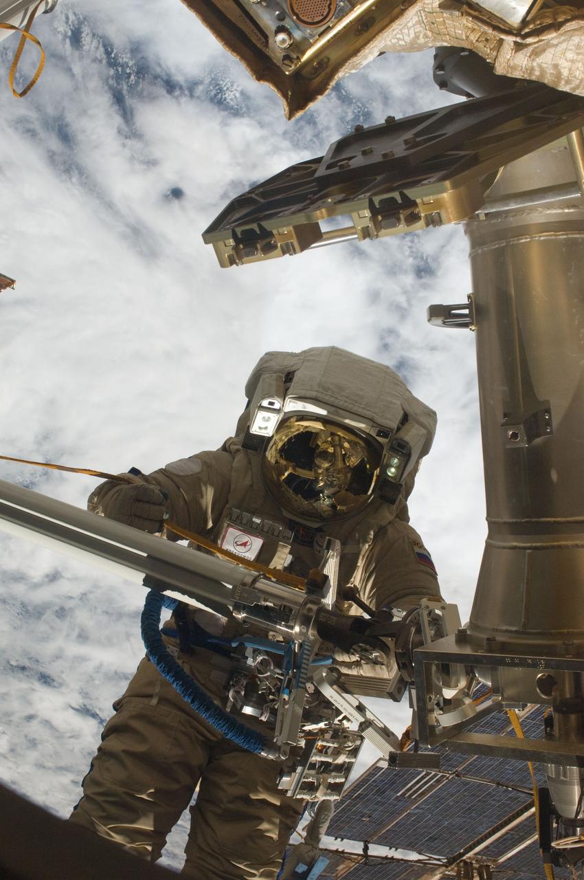 ISS030-E-079991 (16 Feb. 2012) --- Russian cosmonaut Oleg Kononenko, Expedition 30 flight engineer, participates in a session of extravehicular activity (EVA) to continue outfitting the International Space Station. During the six-hour, 15-minute spacewalk, Kononenko and Russian cosmonaut Anton Shkaplerov (out of frame), flight engineer, moved the Strela-1 crane from the Pirs Docking Compartment to begin preparing the Pirs for its replacement next year with a new laboratory and docking module. The duo used another boom, the Strela-2, to move the hand-operated crane to the Poisk module for future assembly and maintenance work. Both telescoping booms extend like fishing rods and are used to move massive components outside the station. On the exterior of the Poisk Mini-Research Module 2 (MRM2), they also installed the Vinoslivost Materials Sample Experiment, which will investigate the influence of space on the mechanical properties of the materials. The spacewalkers also collected a test sample from underneath the insulation on the Zvezda Service Module to search for any signs of living organisms. Both spacewalkers wore Russian Orlan spacesuits bearing blue stripes and equipped with NASA helmet cameras.