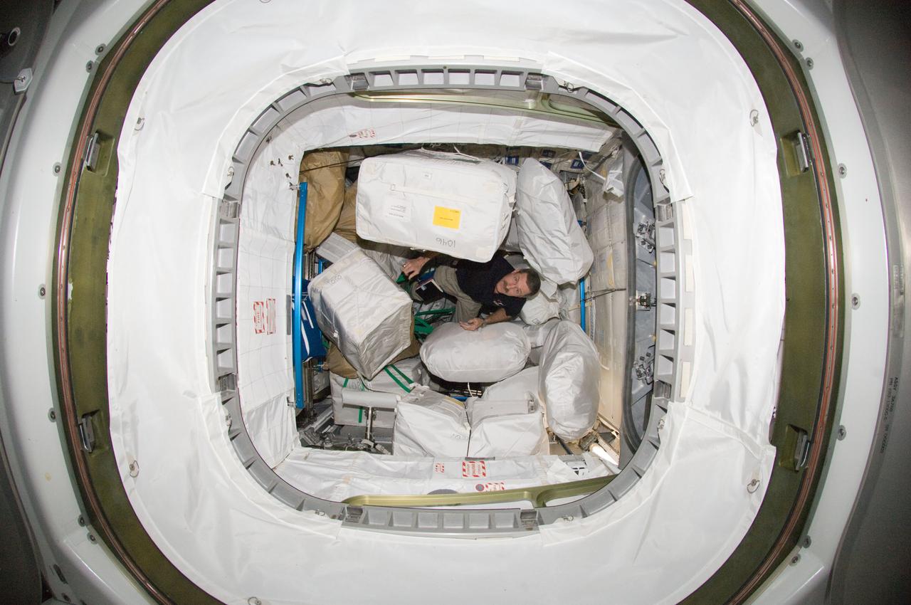 ISS030-E-115930 (2 March 2012) --- NASA astronaut Dan Burbank, Expedition 30 commander, is pictured among stowage containers in the Leonardo Permanent Multipurpose Module (PMM) of the International Space Station.
