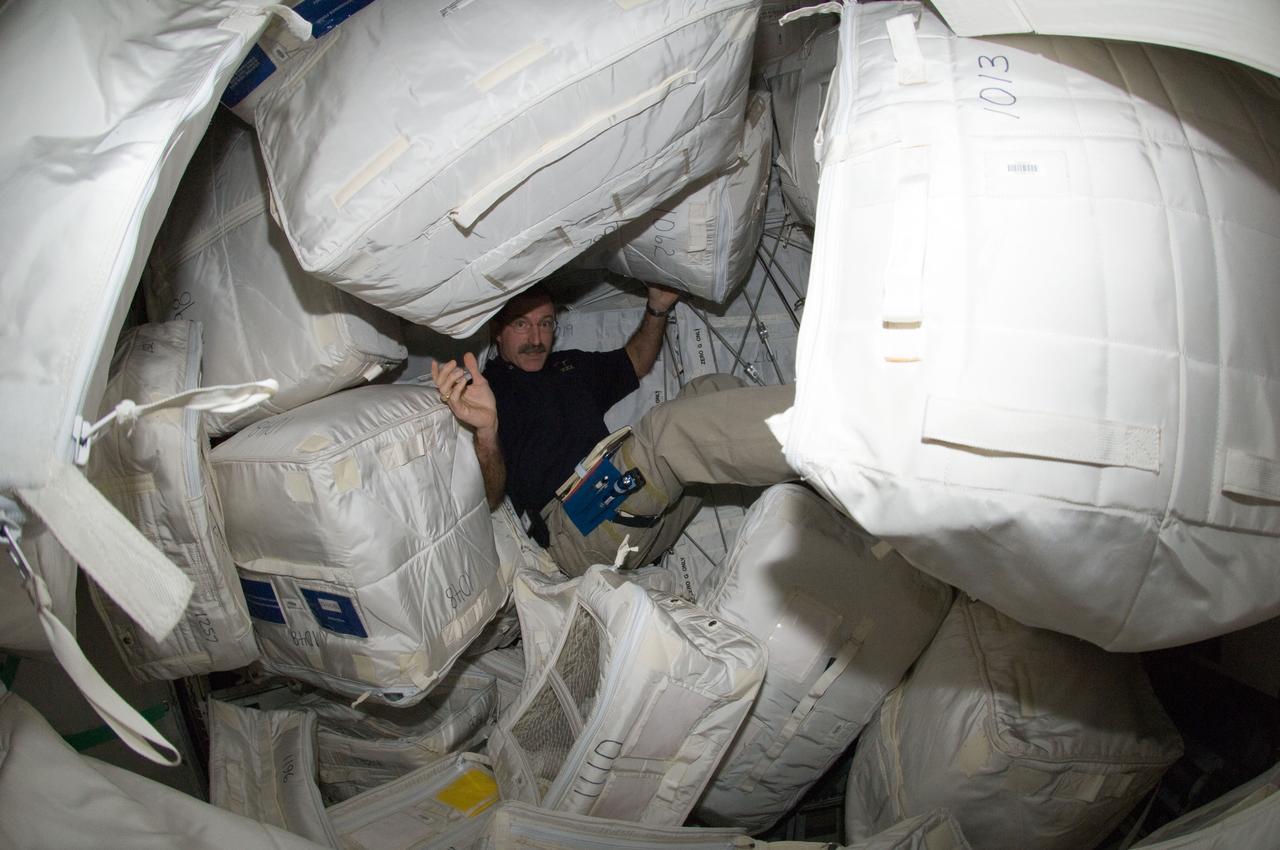 ISS030-E-115935 (2 March 2012) --- NASA astronaut Dan Burbank, Expedition 30 commander, is pictured among stowage containers in the Leonardo Permanent Multipurpose Module (PMM) of the International Space Station.