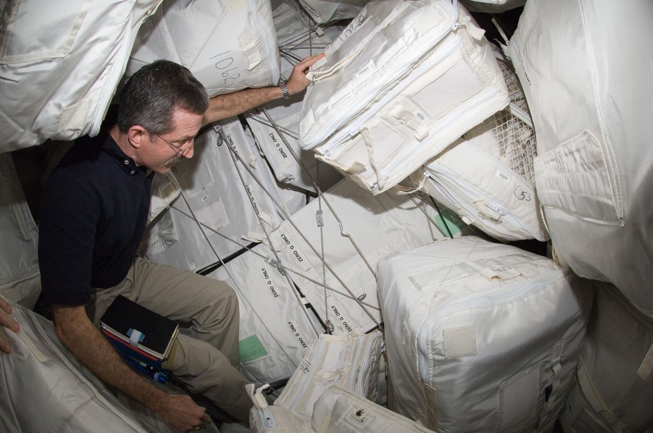 ISS030-E-115939 (2 March 2012) --- NASA astronaut Dan Burbank, Expedition 30 commander, is pictured among stowage containers in the Leonardo Permanent Multipurpose Module (PMM) of the International Space Station.