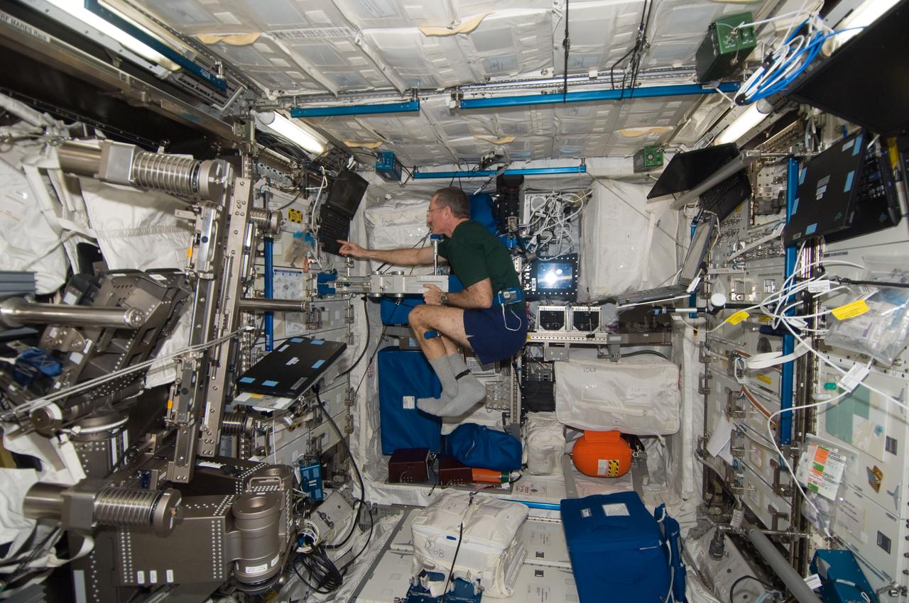 ISS030-E-117437 (1 Feb. 2012) --- NASA astronaut Dan Burbank, Expedition 30 commander, uses the Space Linear Acceleration Mass Measurement Device (SLAMMD) in the Columbus laboratory of the International Space Station.