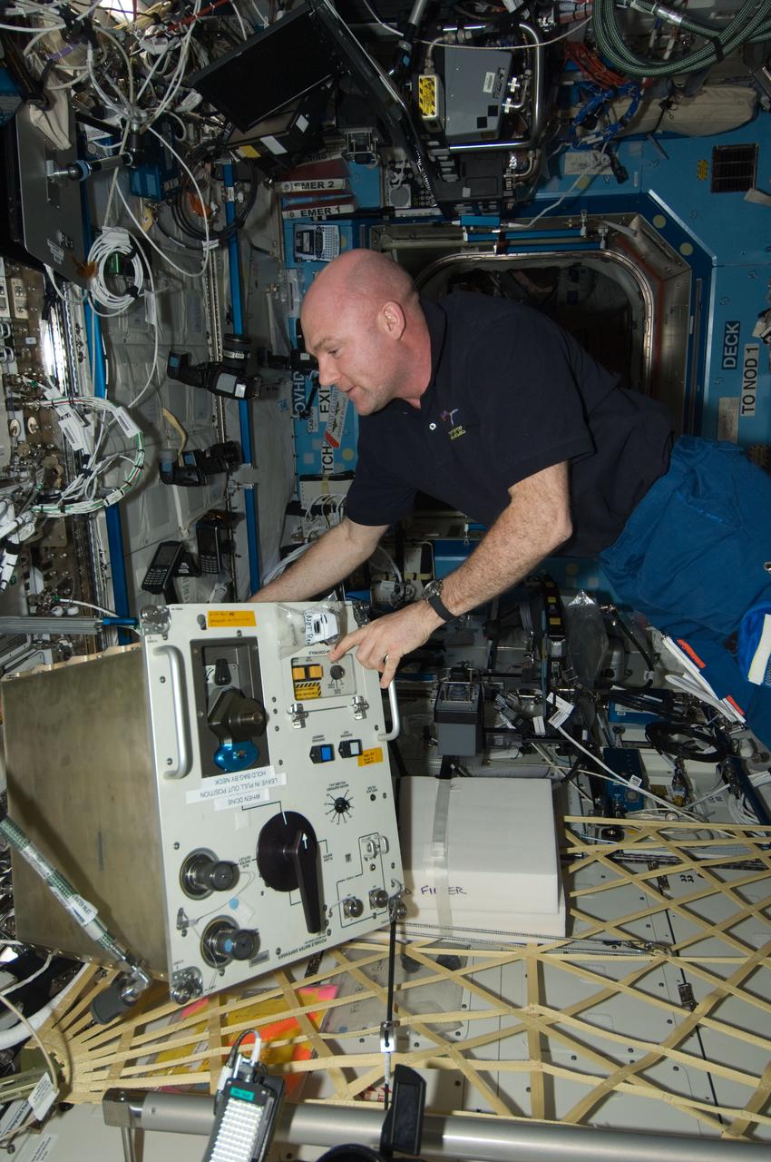 ISS030-E-117471 (2 Feb. 2012) --- European Space Agency astronaut Andre Kuipers, Expedition 30 flight engineer, performs scheduled in-flight maintenance on the Potable Water Dispenser (PWD) in the Destiny laboratory of the International Space Station.