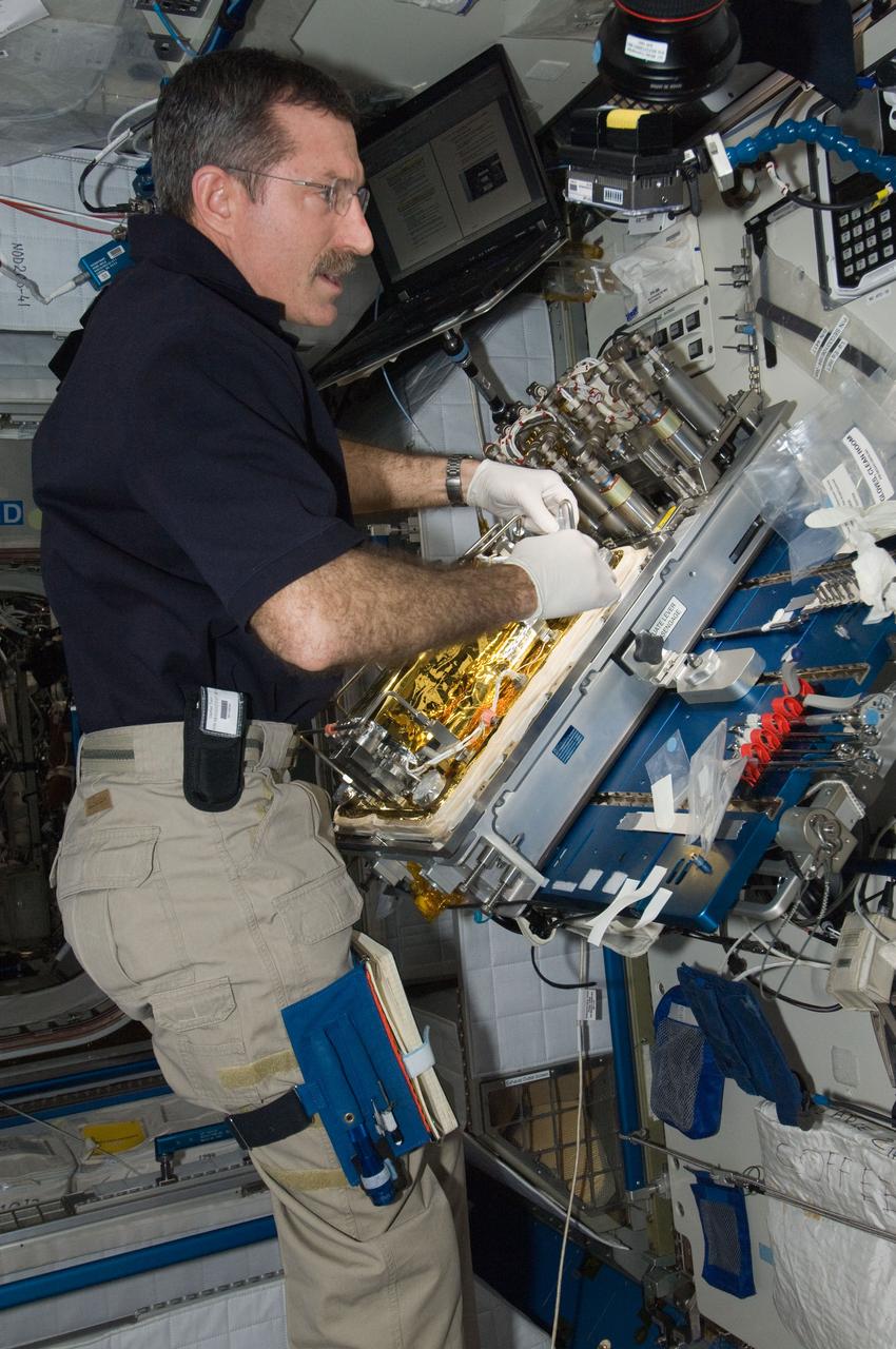 ISS030-E-128877 (9 March 2012) --- At a workstation in the International Space Station?s Harmony node, NASA astronaut Dan Burbank, Expedition 30 commander, replaces a Catalytic Reactor in the Water Recovery System.
