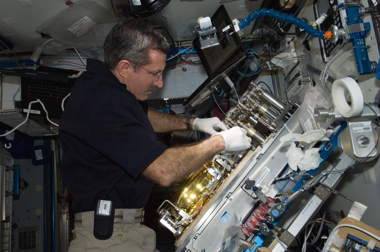 ISS030-E-128879 (9 March 2012) --- At a workstation in the International Space Station?s Harmony node, NASA astronaut Dan Burbank, Expedition 30 commander, replaces a Catalytic Reactor in the Water Recovery System.