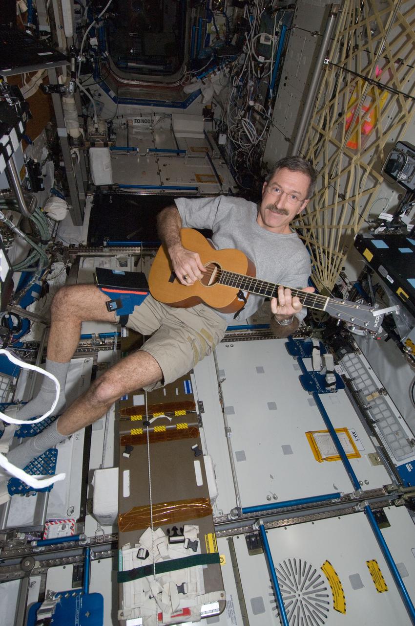 ISS030-E-132620 (10 March 2012) --- NASA astronaut Dan Burbank, Expedition 30 commander, plays a guitar in the Destiny laboratory of the International Space Station.