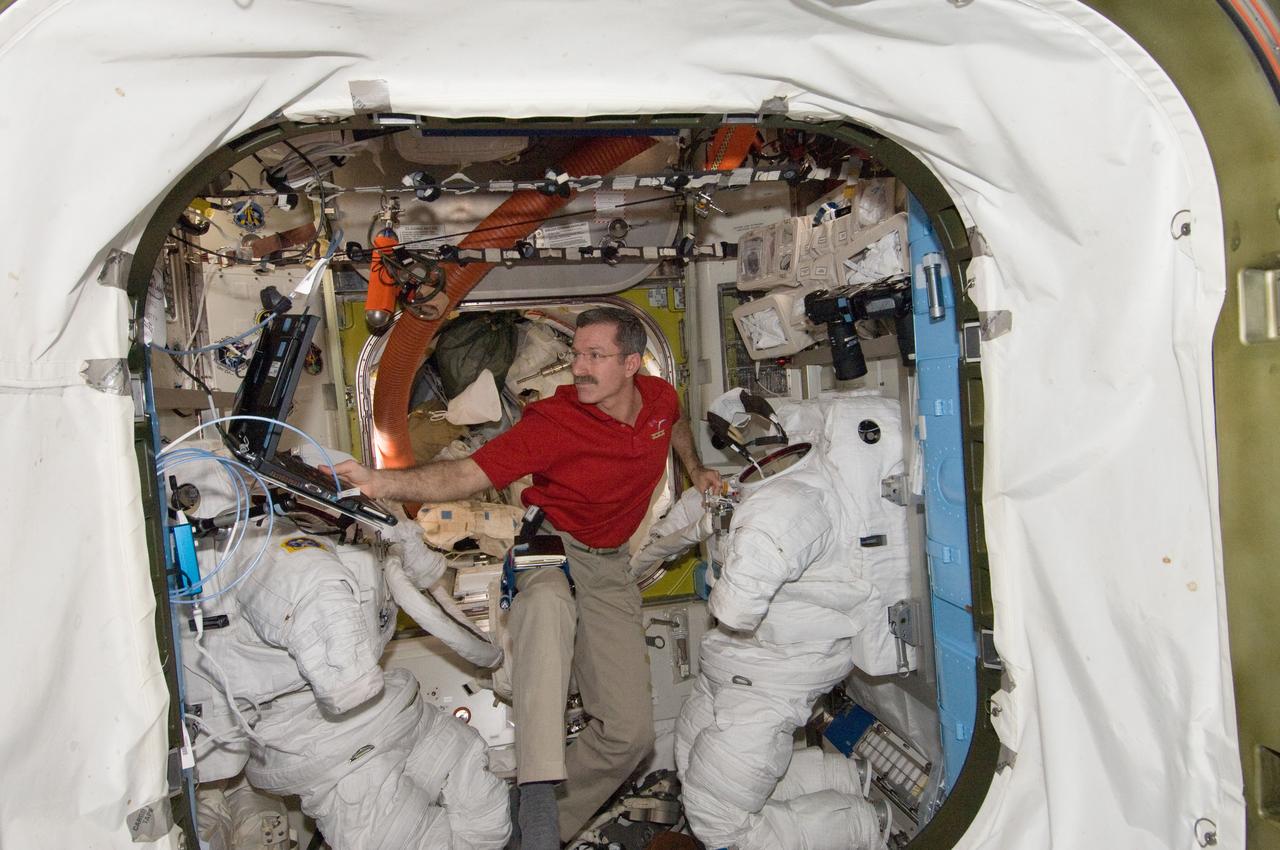 ISS030-E-148275 (13 March 2012) --- NASA astronaut Dan Burbank, Expedition 30 commander, performs routine in-flight maintenance on Extravehicular Mobility Unit (EMU) equipment in the Quest airlock of the International Space Station.