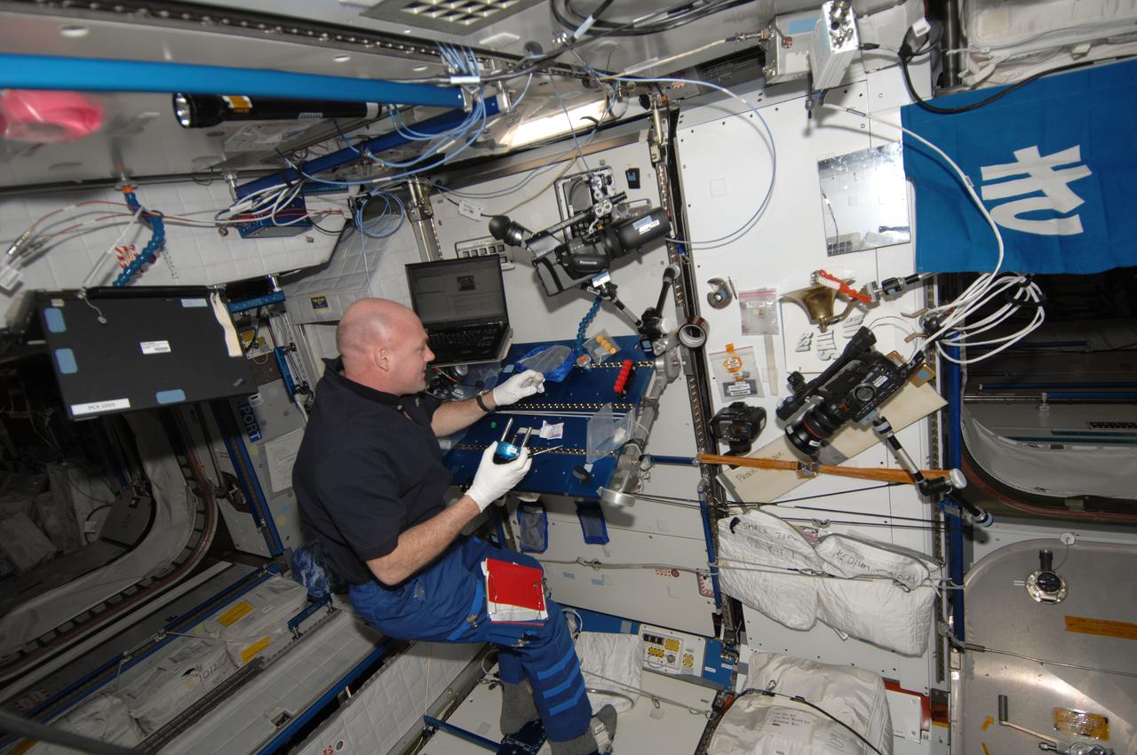 ISS030-E-156300 (23 Jan. 2012) --- European Space Agency astronaut Andre Kuipers, Expedition 30 flight engineer, lubricates and cleans the beverage adapter on the Potable Water Dispenser (PWD) in the Harmony node of the International Space Station.