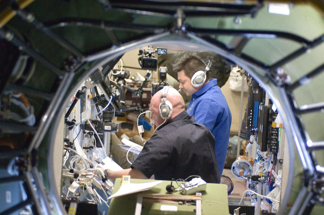 ISS030-E-175600 (28 March 2012) --- European Space Agency astronaut Andre Kuipers (foreground) and Russian cosmonaut Oleg Kononenko, both Expedition 30 flight engineers, monitor the approach and docking of ESA?s ?Edoardo Amaldi? Automated Transfer Vehicle-3 (ATV-3) in the Zvezda Service Module of the International Space Station.