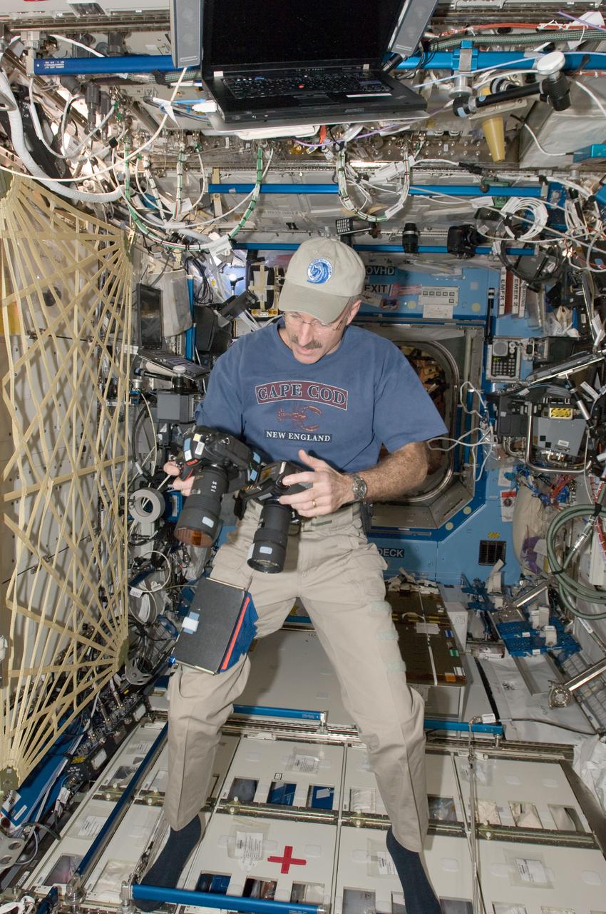 ISS030-E-175782 (15 Jan. 2012) --- NASA astronaut Dan Burbank, Expedition 30 commander, works with two still cameras mounted together in the Destiny laboratory of the International Space Station. One camera is an infrared modified still camera.