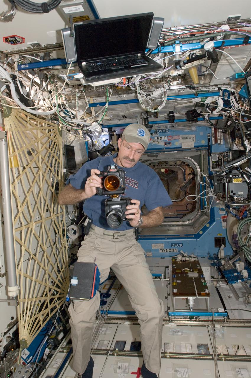 ISS030-E-175784 (15 Jan. 2012) --- NASA astronaut Dan Burbank, Expedition 30 commander, works with two still cameras mounted together in the Destiny laboratory of the International Space Station. One camera is an infrared modified still camera.