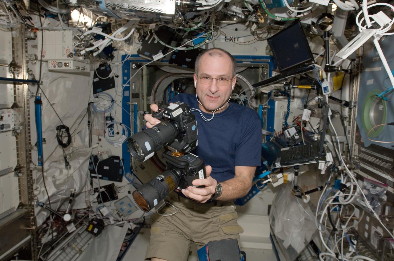 ISS030-E-175788 (15 Jan. 2012) --- NASA astronaut Don Pettit, Expedition 30 flight engineer, is pictured with two still cameras mounted together in the Destiny laboratory of the International Space Station. One camera is an infrared modified still camera.