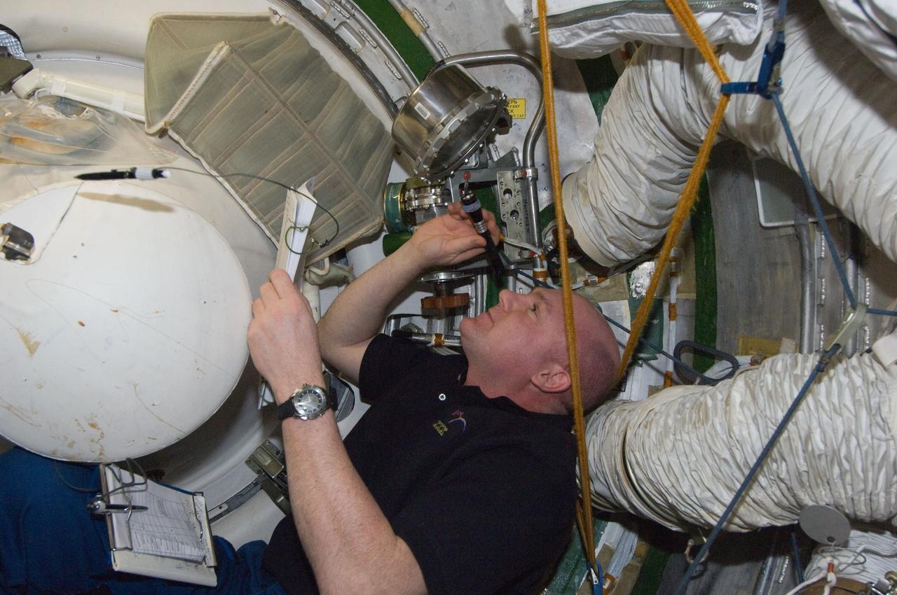 ISS030-E-177373 (29 March 2012) --- European Space Agency astronaut Andre Kuipers, Expedition 30 flight engineer, conducts a leak check in the Zvezda Service Module transfer tunnel/ATV vestibule of the International Space Station.