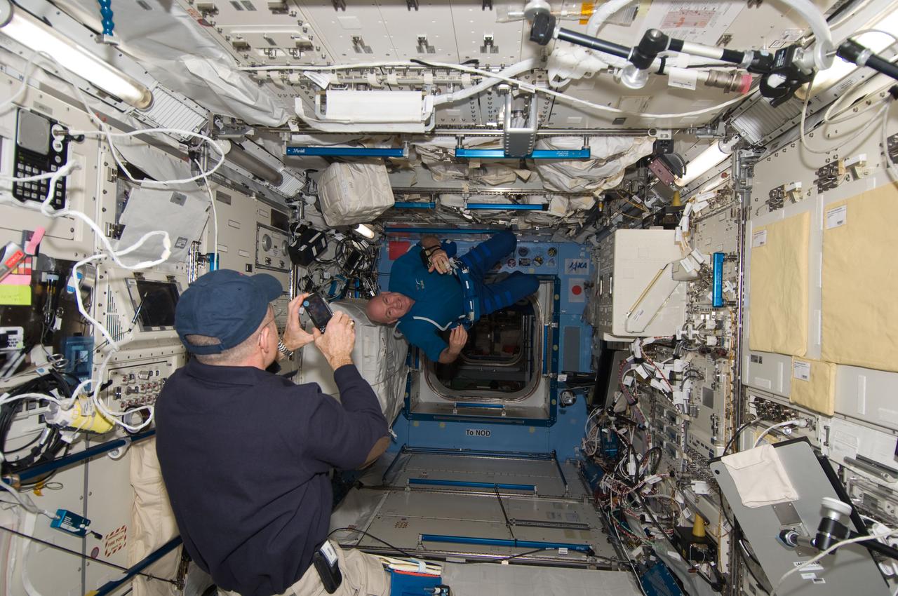 ISS030-E-235481 (4 Jan. 2012) --- NASA astronaut Don Pettit (foreground), Expedition 30 flight engineer, photographs European Space Agency astronaut Andre Kuipers, flight engineer, in the Kibo laboratory of the International Space Station.