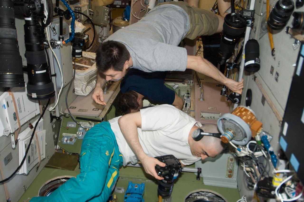 ISS030-E-238160 (19 April 2012) --- From windows in the International Space Station’s Zvezda Service Module, Russian cosmonauts Oleg Kononenko (top), Anatoly Ivanishin (foreground) and Anton Shkaplerov, all Expedition 30 flight engineers, watch the Russian Progress 46 spacecraft after it undocked from the Pirs Docking Compartment.