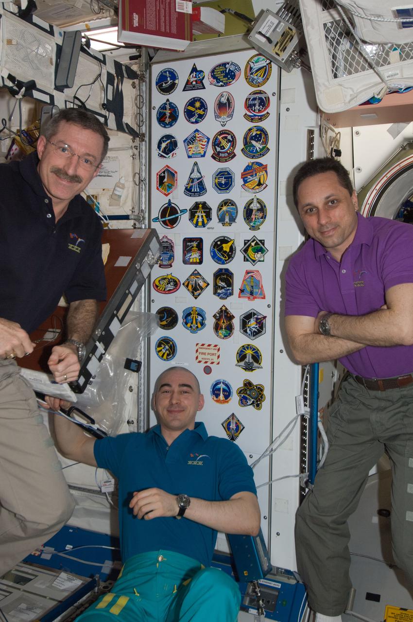 ISS030-E-241355 (21 April 2012) --- In the Unity node, NASA astronaut Dan Burbank (left), Expedition 30 commander; along with Russian cosmonauts Anton Shkaplerov (right) and Anatoly Ivanishin, both flight engineers, pose for a photo near the collection of insignias representing shuttle crews who have worked on the International Space Station.