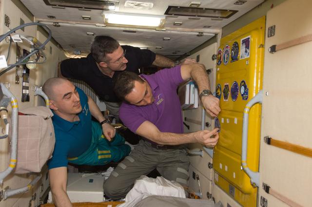 NASA image: Expedition 30 crewmembers prepare to add patch to Soyuz TMA-22