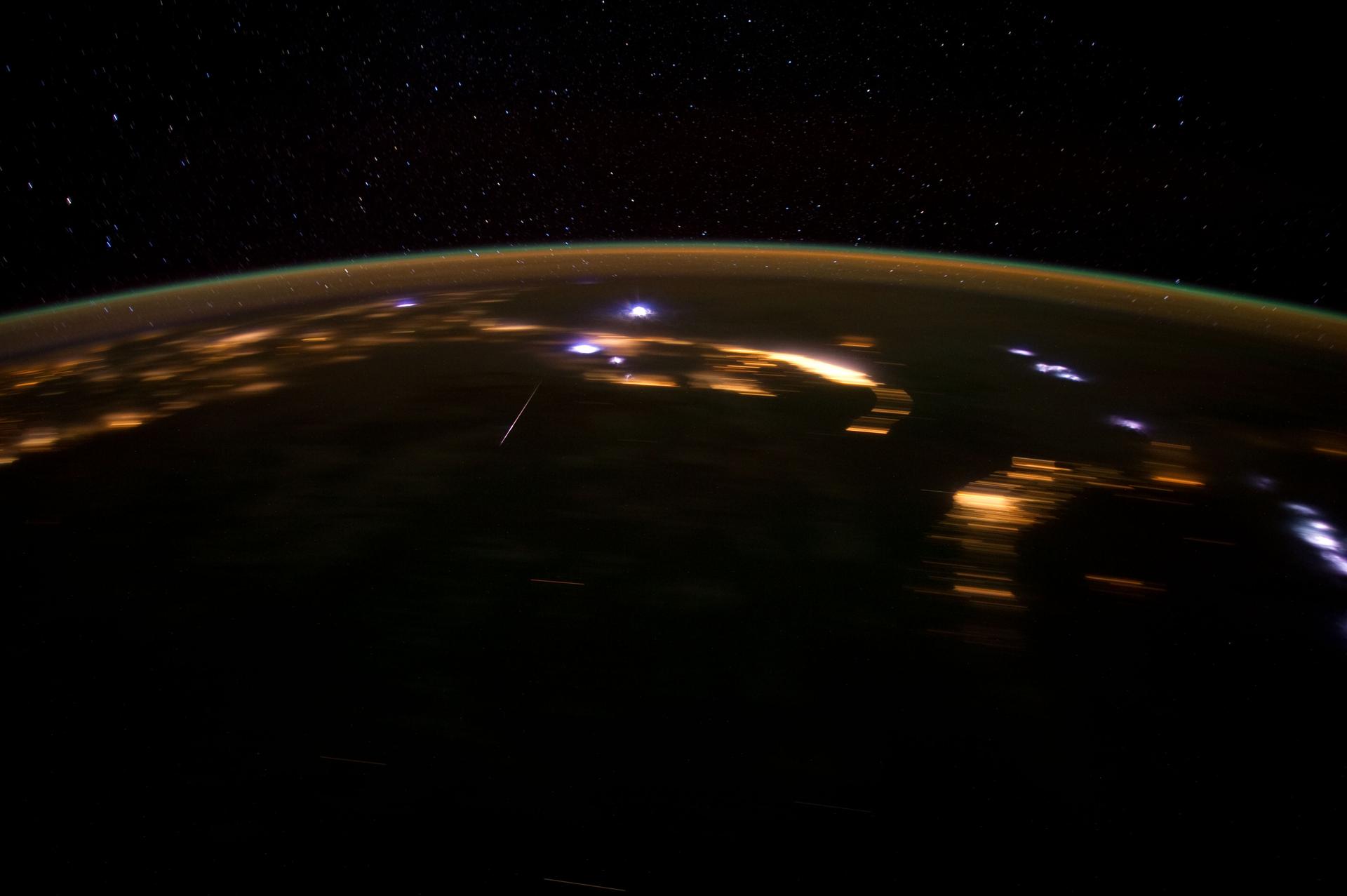 : White meteors burn up in the atmosphere above Earth in this night video image.